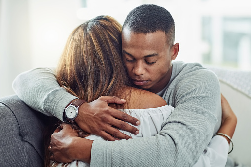 Cropped shot of a young attractive couple embracing each other on the sofa at home