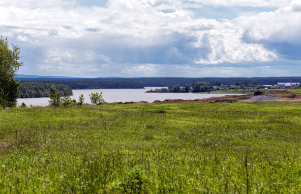istock Thunderclouds over the river. Summer lawn on the river bank 1023476042