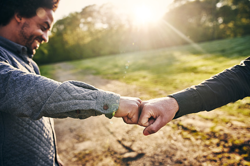 Cropped shot of two men fist bumping while team building at a company retreat