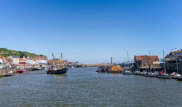 Photo of Whitby harbour with fishing boat.