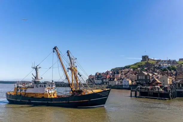 Photo of Whitby harbour with fishing boat.