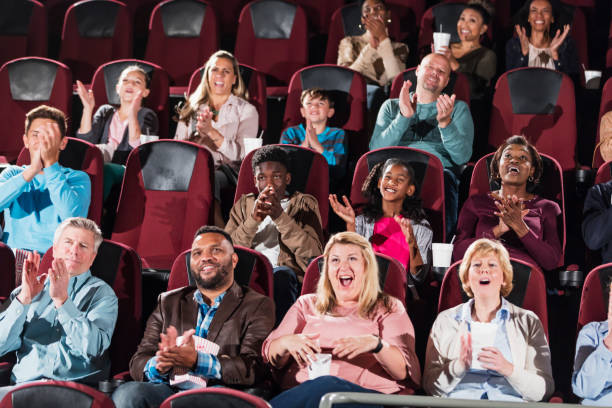 istock Multi-ethnic audience in movie theater, clapping 1023481078