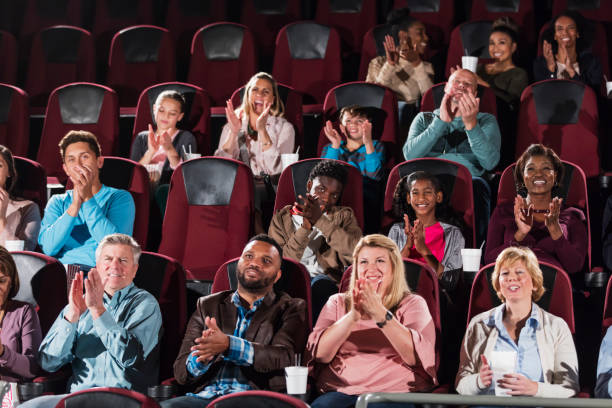 istock Multi-ethnic audience in movie theater, clapping 1023481196