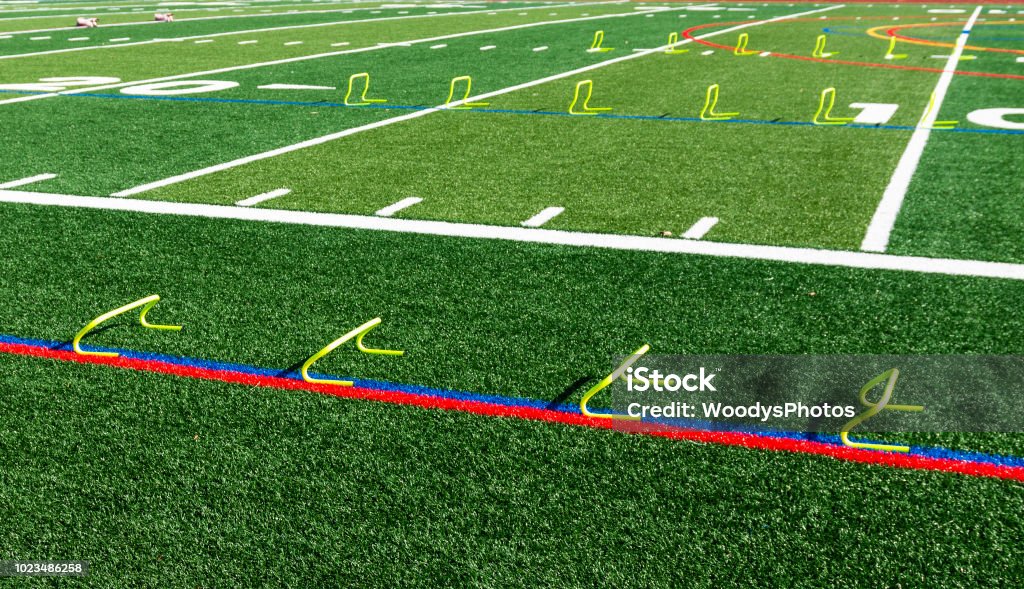 Yellow mini hurdles set up on a field Six and twelve inch yellow mini hurdles are set up on a green turf field for speed and agility practice. Agility Stock Photo