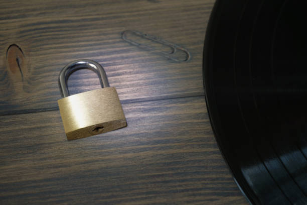istock Padlock next to vinyl record on wooden background 1023486470