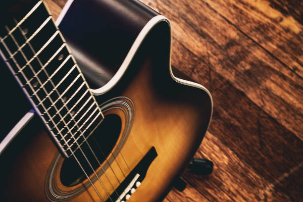 istock acoustic guitar on a wooden background.grain and noise effect 1023486946