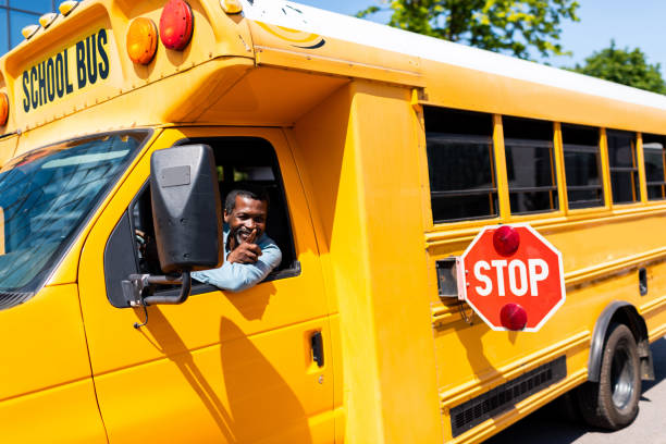 istock smiling mature african american bus driver looking out window and gesturing 1023490470