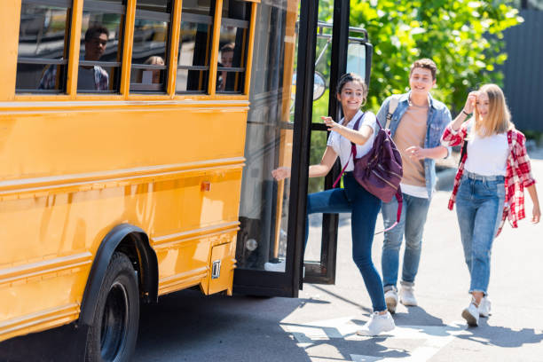 istock happy teen students walking into school bus 1023490478