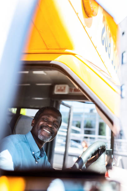 istock happy mature african american bus driver looking at camera 1023490534