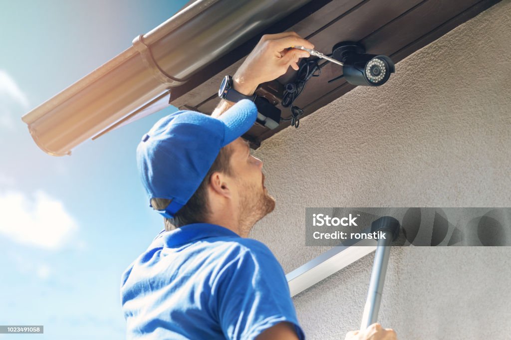 homme installation caméra ip extérieure de surveillance pour la sécurité à la maison - Photo de Caméra de surveillance libre de droits