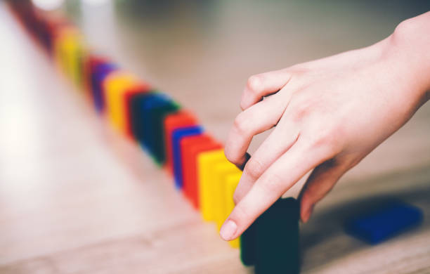 female hand set up domino blocks.