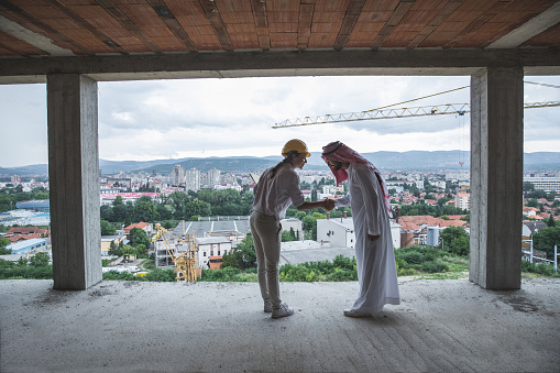 Architect handshaking with arab investor at the construction site after making an agreement
