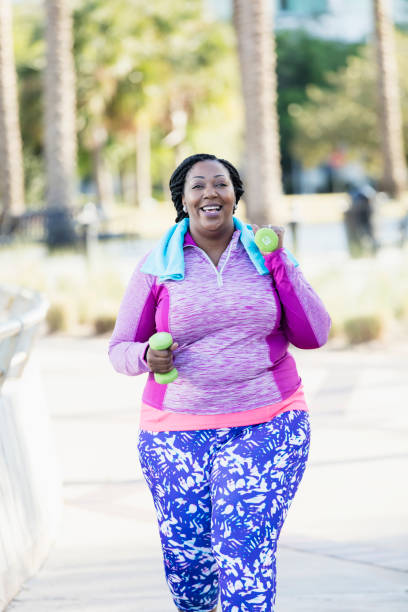 istock African-American woman exercising with hand weights 1023502450