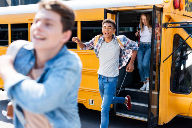 group of teen students running out of school bus group of teen students running out of school bus back to school teens stock pictures, royalty-free photos & images