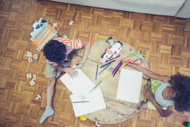 istock Cute mixed - race siblings playing and drawing at home 1023505940