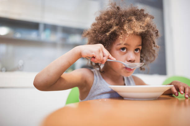 istock Cute mixed - race girl having breakfast at home 1023506218