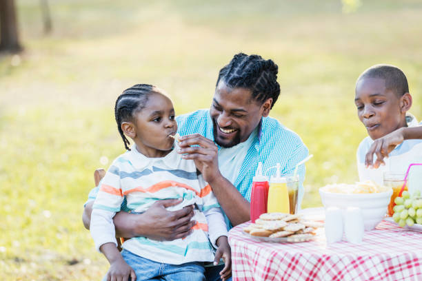 istock Father, two boys at cookout, eating potato chips 1023513248