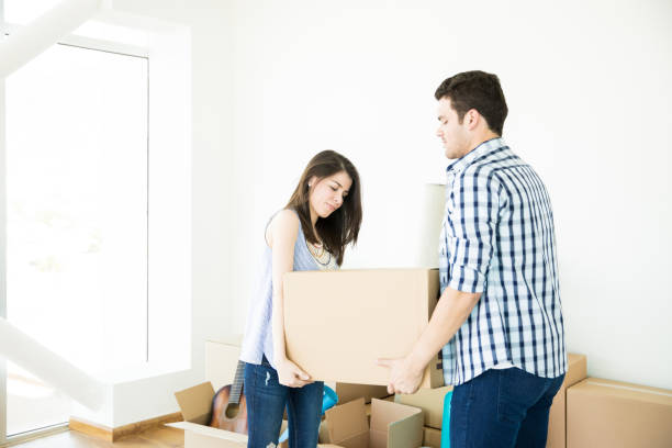 istock Couple Carrying Moving Boxes Together In New Home 1023517014