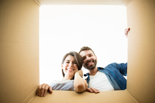 istock Couple Looking In Corrugated Box In New Apartment 1023517626