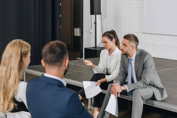 istock business trainers sitting on stage with documents in hub 1023518622