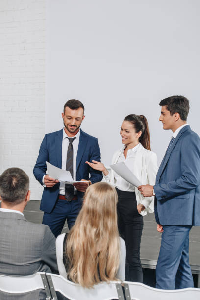 istock smiling businesspeople talking about documents during training in hub 1023518808