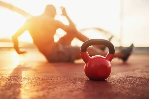 Photo of Kettle bell in focus, fitness training at early morning.