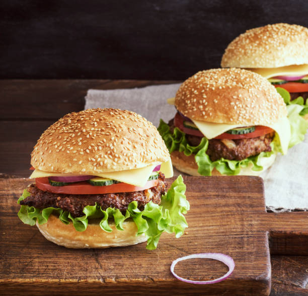 istock Fresh burger closeup on wooden rustic cutting board 1023523806