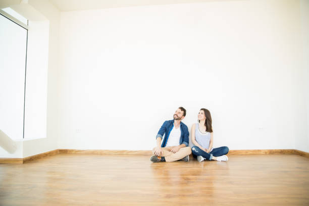 istock Owners Looking Away While Sitting On Floor In New Home 1023523876