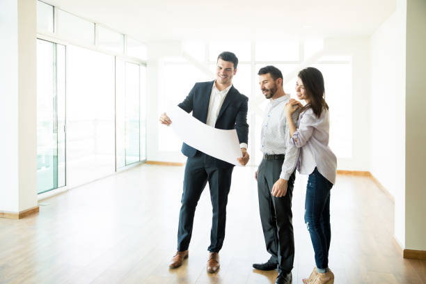 istock Real Estate Agent Discussing Apartment Layout With Couple In Empty Room 1023524074