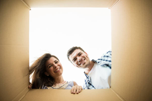 istock Successful Homeowners Peeking In Moving Box At New Apartment 1023524620