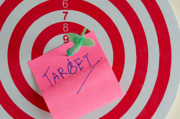 istock reen dart on pink paper that write target word for business goal conpept 1023528018