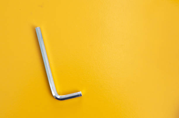 Allen key on yellow background Allen key on yellow background hex wrench stock pictures, royalty-free photos & images