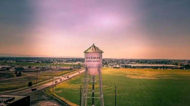 Aerial view of the new district in Bozeman Montana, Cannery Row. Water tower, field and new buildings at sunset with a dramatic sky.