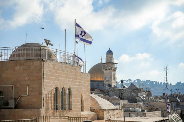 The Israeli flag against the backdrop of the Al Aksa mosque in the Jewish quarter in the old city of Jerusalem near the Western Wall Jerusalem, Israel, August 18, 2018 : The Israeli flag against the backdrop of the Al Aksa mosque in the Jewish quarter in the old city of Jerusalem near the Western Wall al aksa stock pictures, royalty-free photos & images