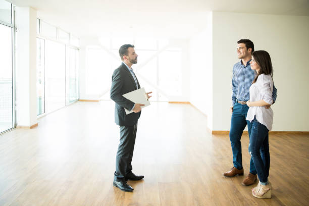 istock Couple With Real Estate Agent Visiting New House 1023540980