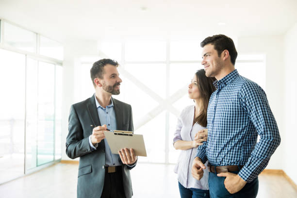 istock Estate Agent Explaining Contract To Couple In New Apartment 1023541006