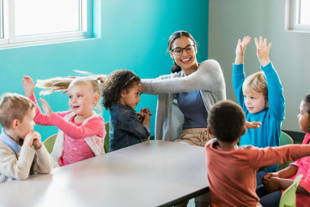 istock Multi-ethnic preschool teacher and students in classroom 1023542518
