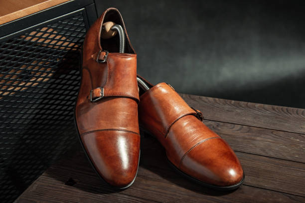 Elegant brown monk shoes with double strap on a wooden table stock photo