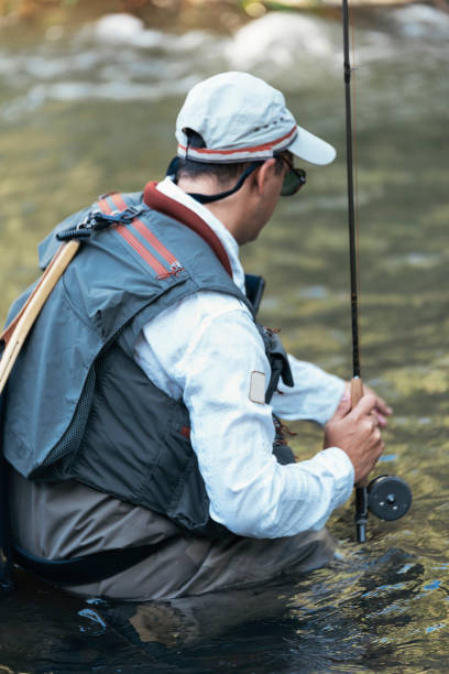 istock Fly fisherman using flyfishing rod in beautiful river 1023550882
