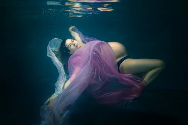 Pregnant woman under water.