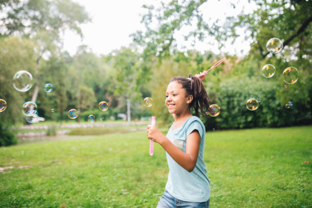 istock Joyful girl running and making soap bubbles at the park 1023551454