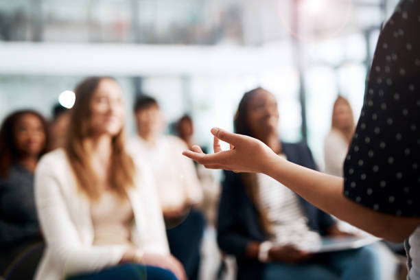 Great speakers know their audience Cropped shot of a businesswoman delivering a speech during a conference gesturing stock pictures, royalty-free photos & images