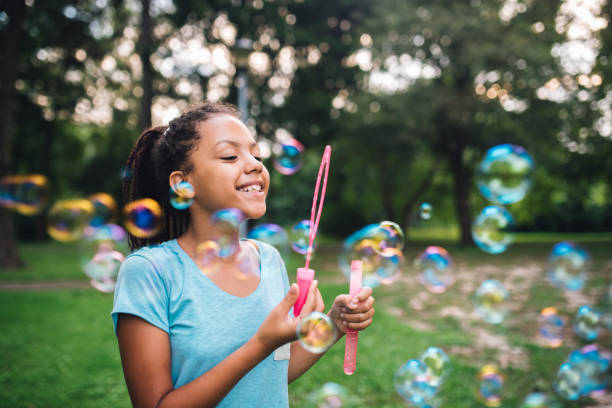 istock Beautiful girl making soap bubbles outdoors 1023551844