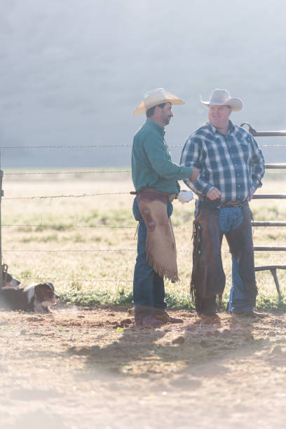 istock Two ranchers standing at the animal pen and having a conversation 1023552164