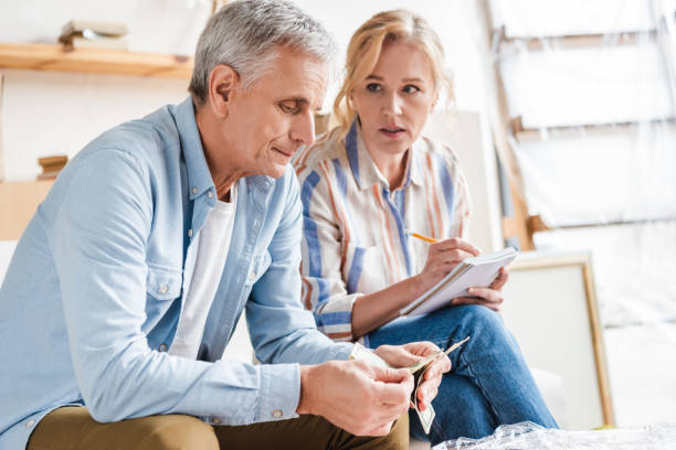 istock serious elderly couple counting money and taking notes during relocation 1023552702