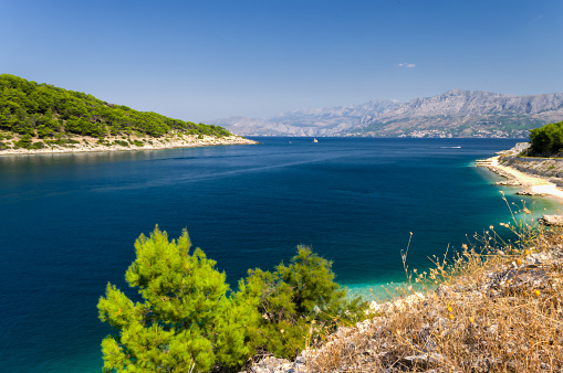View of the Croatian coast near the town of Pucisca, island of Brac, Dalmatia, Croatia. Clean blue sea, beach and mountainous coast. Summer travel destination. HDR photo.