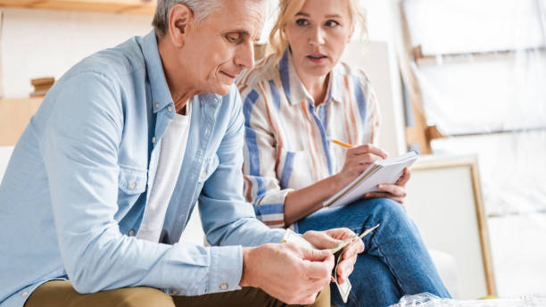 istock serious senior couple counting money and taking notes during relocation 1023552760