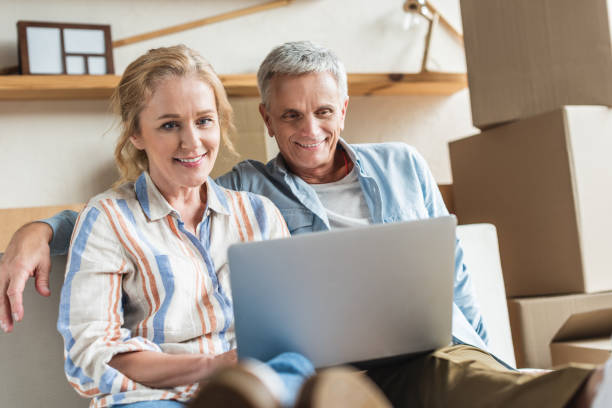 istock happy senior couple using laptop together during relocation 1023557432