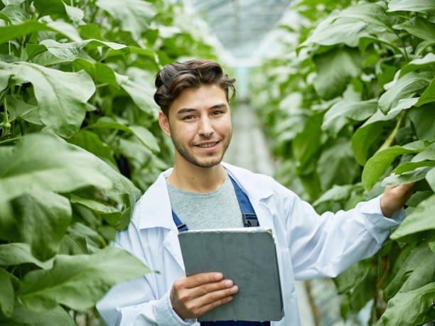 istock Smiling scientist with tablet among plants 1023562308
