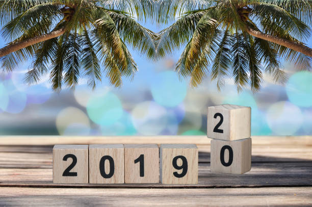 istock Wood cube number 2019 and 2020 on planks on tropical beach background 1023562906